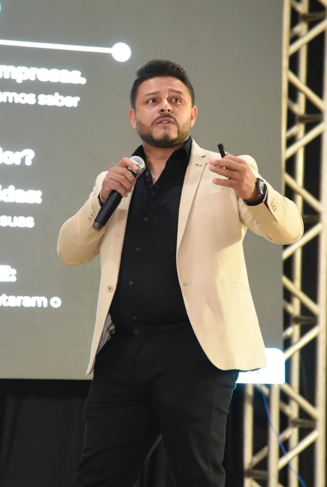Adriano Silva falando ao microfone em um evento para empresários